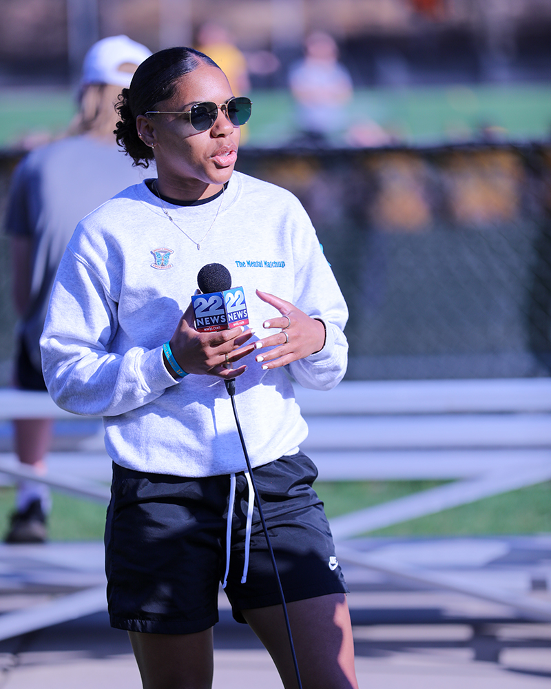 AIC women's basketball captain Kayla Robinson speaks to the local news during AIC Women's Lacrosse's Morgan's Message Game. 