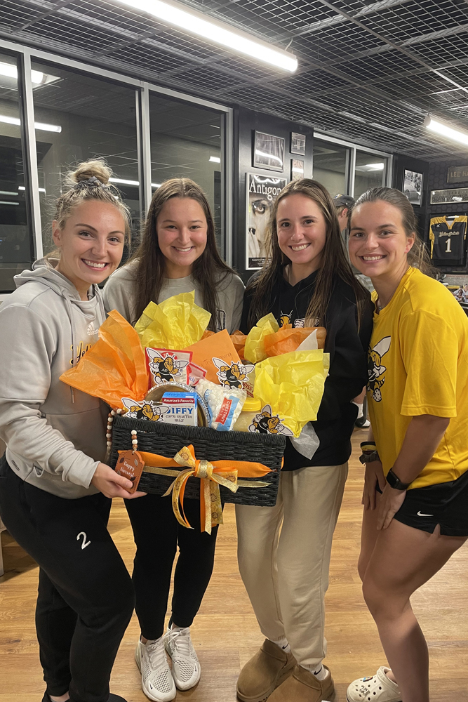 AIC student-athletes holding items for the Thanksgiving Community Service Project